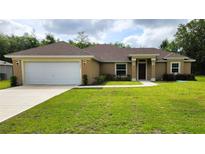 Charming single-story home with a well-manicured lawn and an attached two-car garage at 15407 Sw 59Th Avenue Rd, Ocala, FL 34473