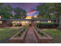 Charming single-story brick home featuring a landscaped front yard, brick planter, and inviting entrance with a wood door at 1781 Se 85Th Street Rd, Ocala, FL 34480