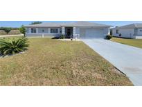 Charming single-story home featuring a well-maintained lawn and a two-car garage at 6239 Sw 98Th Loop, Ocala, FL 34476