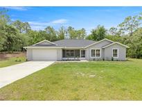 Charming one-story home features a two-car garage and well-maintained lawn, enhancing its curb appeal at 9835 Sw 207Th Cir, Dunnellon, FL 34431
