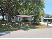 Quaint single-story home with mature trees in the front yard offers a cozy curb appeal at 11025 Sw 64Th Ave, Ocala, FL 34476