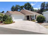 Beautiful one-story home with a two-car garage, an extra long driveway, and inviting front porch seating at 3154 Merrit Ln, The Villages, FL 32163