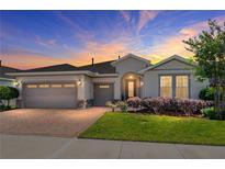 Charming single-story home boasts a three-car garage, arched entryway, and beautifully landscaped front yard at 4379 Nw 56Th Ct, Ocala, FL 34482