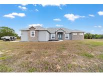 Charming single-story home featuring a stucco exterior, stone accents, and a well-manicured lawn at 5489 Nantahala Ln, Lady Lake, FL 32159