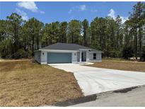 Charming single-story home with a blue garage door and a long driveway leading up to the house at 6178 Sw 207Th Ct, Dunnellon, FL 34431