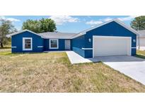 Charming blue single-story home with a two-car garage and well-lit front entrance at 6570 Sw 129Th Loop, Ocala, FL 34473
