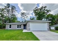 Charming single-story home featuring a two-car garage, well-manicured lawn, and beautiful landscaping at 9983 Sw 188Th Cir, Dunnellon, FL 34432