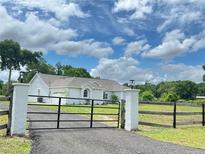 Attractive single-story home with a black gated entrance and a well-maintained lawn at 13430 Ne 30Th Ct, Anthony, FL 32617