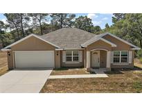 Charming single-Gathering home with a two-car garage, manicured lawn, and well-maintained landscaping at 171 Oak Cir, Ocala, FL 34472
