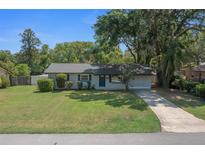 Charming single-story home with a well-maintained lawn and mature trees under a clear blue sky at 511 Se 29Th Ter, Ocala, FL 34471
