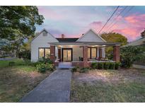 Charming home with a covered front porch, brick pillars, and a well-maintained landscaped yard at 716 Se Wenona Ave, Ocala, FL 34471