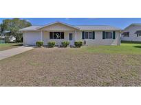 Charming single-story home featuring a well-maintained lawn and a welcoming front porch at 8443 Sw 109Th Place, Ocala, FL 34481