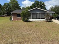 Charming single-story brick home featuring a screened-in porch and well-maintained landscaping at 8556 Sw 109Th Lane Rd, Ocala, FL 34481