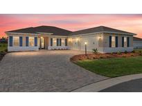 Charming single-story home with a brick driveway, well-maintained lawn, and elegant blue shutters at 10530 Sw 98Th Pl, Ocala, FL 34481