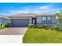 Charming single-story home featuring a brick driveway, lush landscaping, and a neutral color scheme at 4411 Nw 53Rd Ct, Ocala, FL 34482