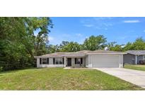Charming single story home featuring a two car garage, manicured lawn, and classic curb appeal at 6306 Pecan Crse, Ocala, FL 34472