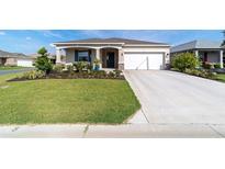 Charming single-story home featuring a well-maintained lawn, attractive landscaping, and an attached two-car garage at 7706 Sw 89Th Ct, Ocala, FL 34481