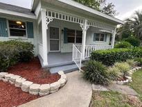 Inviting front porch featuring stone pathway, decorative stone retaining wall, and decorative bushes at 8654 Sw 96Th St # D, Ocala, FL 34481