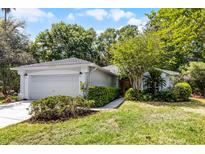Charming single-story home with a well-manicured lawn, lush landscaping, and an attached two-car garage at 9565 Sw 194Th Cir, Dunnellon, FL 34432
