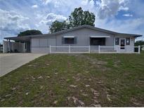 Charming single-story home with a carport, gray exterior, and a well-maintained front yard at 10330 Sw 99Th Ave, Ocala, FL 34481