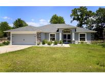 Charming single-story home with a well-manicured lawn and a two-car garage at 11609 Sw 59Th Ter, Ocala, FL 34476
