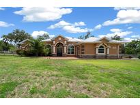 Charming single-story home featuring manicured lawn, neutral colors, and elegant arched windows at 3934 Se 110Th St, Belleview, FL 34420