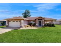 Charming home featuring a lush lawn, two-car garage, and inviting front entrance at 4757 Nw 45Th Ct, Ocala, FL 34482