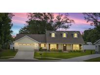 Charming home features a two-car garage, warm lighting, and a well-manicured lawn at 6600 Sw 109Th Ln, Ocala, FL 34476