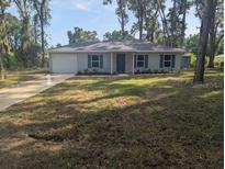 Charming single-story home with a well-maintained lawn and mature trees at 15 Juniper Trail Crse, Ocala, FL 34480