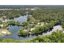 Breathtaking aerial view of a home nestled on a private lake peninsula amidst lush greenery at 19938 Burkitt Rd, Dunnellon, FL 34432