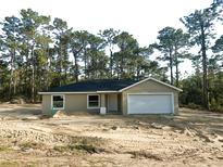 Charming single-story home with a two-car garage and landscaped front yard at 23964 Nw Falcon Ave, Dunnellon, FL 34431