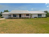 Charming single-story home with a metal roof, attached garage, and well-maintained front yard at 258 Nw 122Nd Ave, Oxford, FL 34484