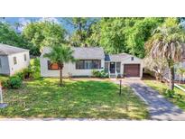 Charming home featuring a well-manicured lawn and a cozy, inviting facade, complemented by lush, mature trees at 426 Sw 13Th St, Ocala, FL 34471