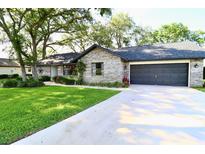 Charming brick home featuring a lush lawn, mature trees and a two-car garage at 5351 Sw 80Th Pl, Ocala, FL 34476
