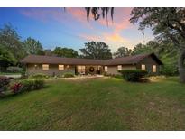 Charming single-story home with a lush green lawn, mature trees, and inviting front porch at 5521 Sw 31St St, Ocala, FL 34474