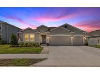 Charming single-story home with a well-manicured lawn and a two-car garage at dusk at 5862 Sw 80Th Ln, Ocala, FL 34476