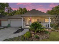 Charming single-story home with a brick facade, attached garage, and a cozy front porch adorned with an American flag at 8712 Sw 92Nd St # C, Ocala, FL 34481