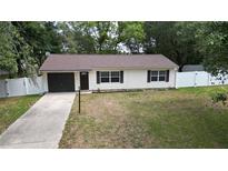 Charming single-story home with a well-maintained lawn and white picket fence at 9 Pine Radial Ct, Ocala, FL 34472