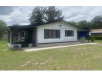Charming single-story home with a screened porch and covered parking area, set on a well-maintained lawn at 9920 Sw 102Nd Pl, Ocala, FL 34481