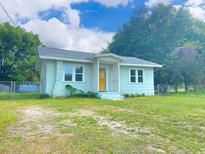 Charming single-story home featuring a well-manicured lawn, freshly painted siding, and bright, welcoming yellow front door at 116 Nw 17Th Pl, Ocala, FL 34475