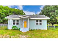 Charming single-story home with light blue paint, a yellow front door, and a well-maintained front yard at 116 Nw 17Th Pl, Ocala, FL 34475