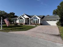 Charming single-story home featuring an attached two-car garage and a well manicured lawn at 11651 Sw 77Th Cir, Ocala, FL 34476
