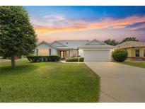 Charming single-Gathering home with manicured lawn, mature trees, and an attached two car garage at 1402 Arredondo Dr, The Villages, FL 32162