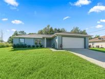 Charming one-story home with a well-manicured lawn, two-car garage, and inviting curb appeal at 32 Pine Course Loop, Ocala, FL 34472