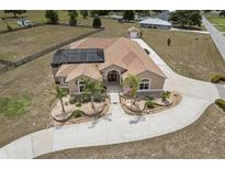 Expansive home featuring a screened pool, a long driveway and lush landscaping at 4725 County Road 121D, Wildwood, FL 34785