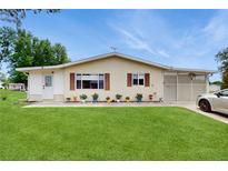 Charming single-story home with a well-maintained lawn and colorful potted plants enhancing curb appeal at 6468 Sw 107Th Pl, Ocala, FL 34476