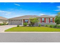 Charming single-story home with a well-manicured lawn, red shutters, and a brick-paved driveway at 8111 Sw 95Th Ct, Ocala, FL 34481