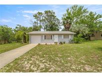 Charming single-story home featuring a one car garage and a well-maintained front yard with mature trees at 8449 Sw 105Th Pl, Ocala, FL 34481