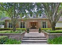 Charming brick home featuring a symmetrical design, manicured landscaping, and a welcoming brick pathway to the entrance at 1300 Sw 43Rd Pl, Ocala, FL 34471