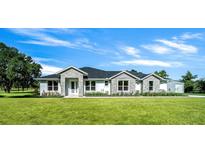 Beautiful single-story home featuring a manicured lawn, stylish stone accents, and an inviting entrance at 1058 Se 59Th St, Ocala, FL 34480